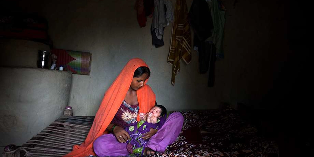 Choti , en su casa de Nepal, contemplando a su bebé. Fotografía de Diana Markosian.