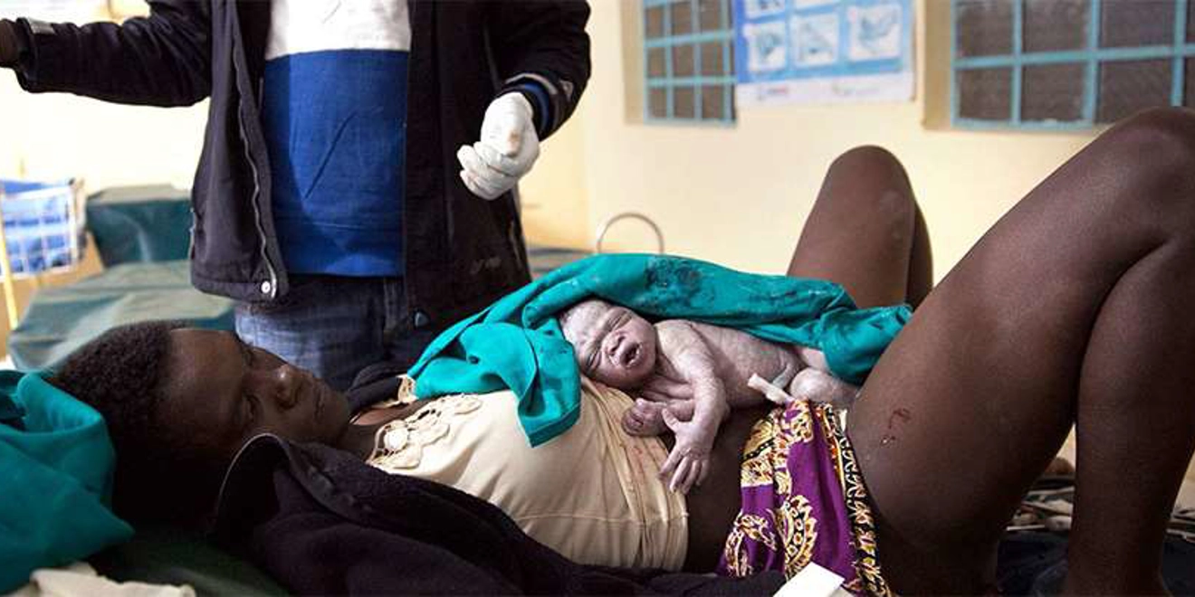 Nelly , acompañada por los doctores, sujeta a su hijo. Fotografía de Bieke Depoorter